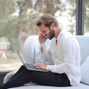 Person smiling while discussing EMDR therapy insurance coverage during a phone call.